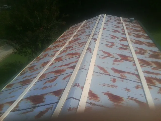 Rusted metal roof panels with new wood purlins before replacement — Storm Damage Roof Repair in Duncanville by Roofing Brothers