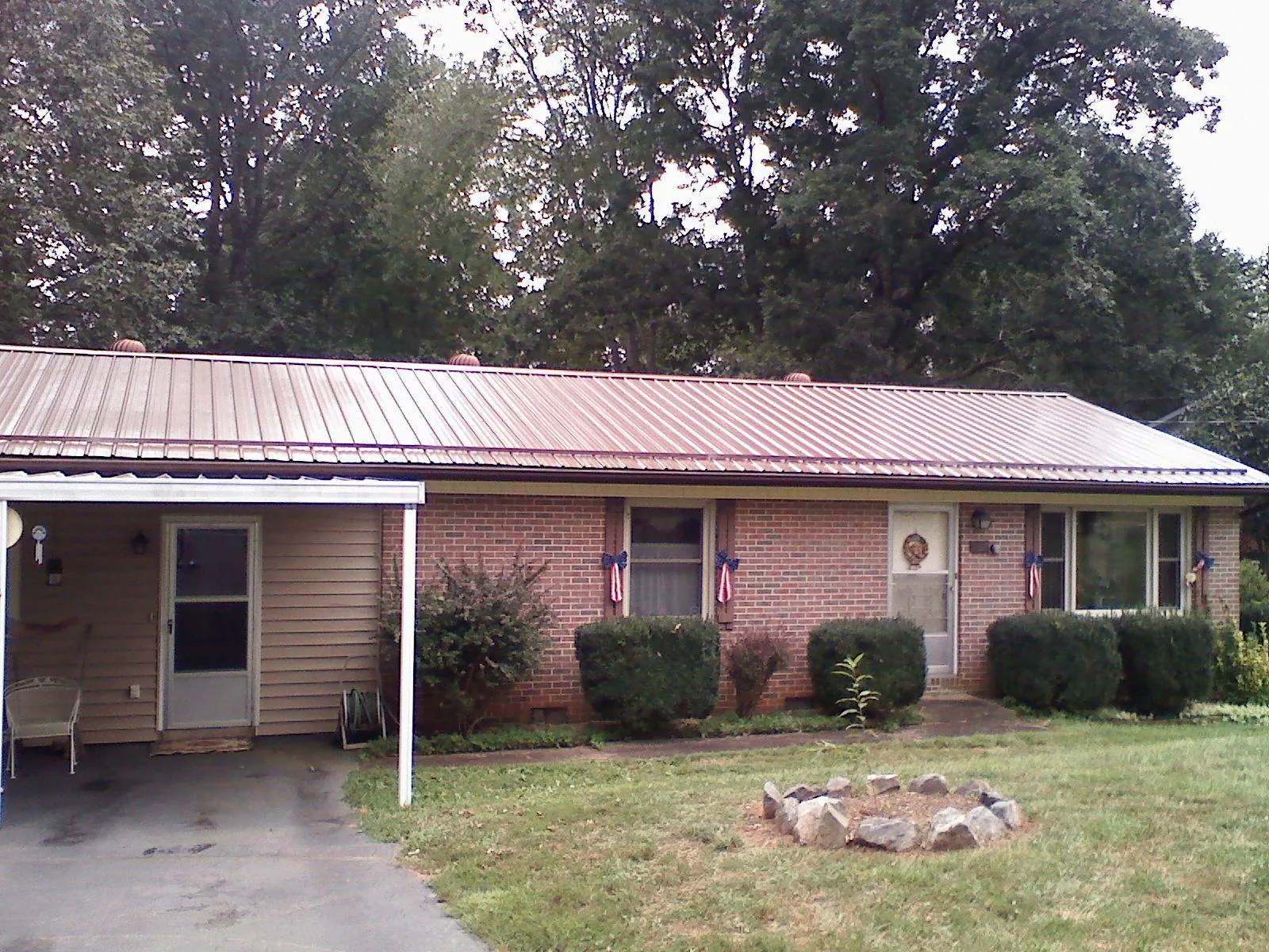 Bronze metal roof and carport on a brick ranch home — Roof Repair work by our crew in Duncanville